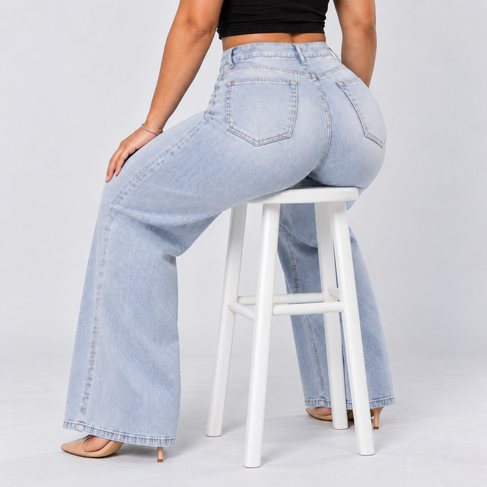 Model seated on a stool wearing light blue stretch wide-leg jeans