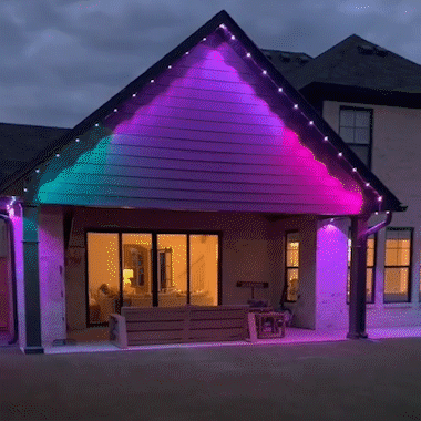 Flowing color effects illuminating a house wall beneath the roofline